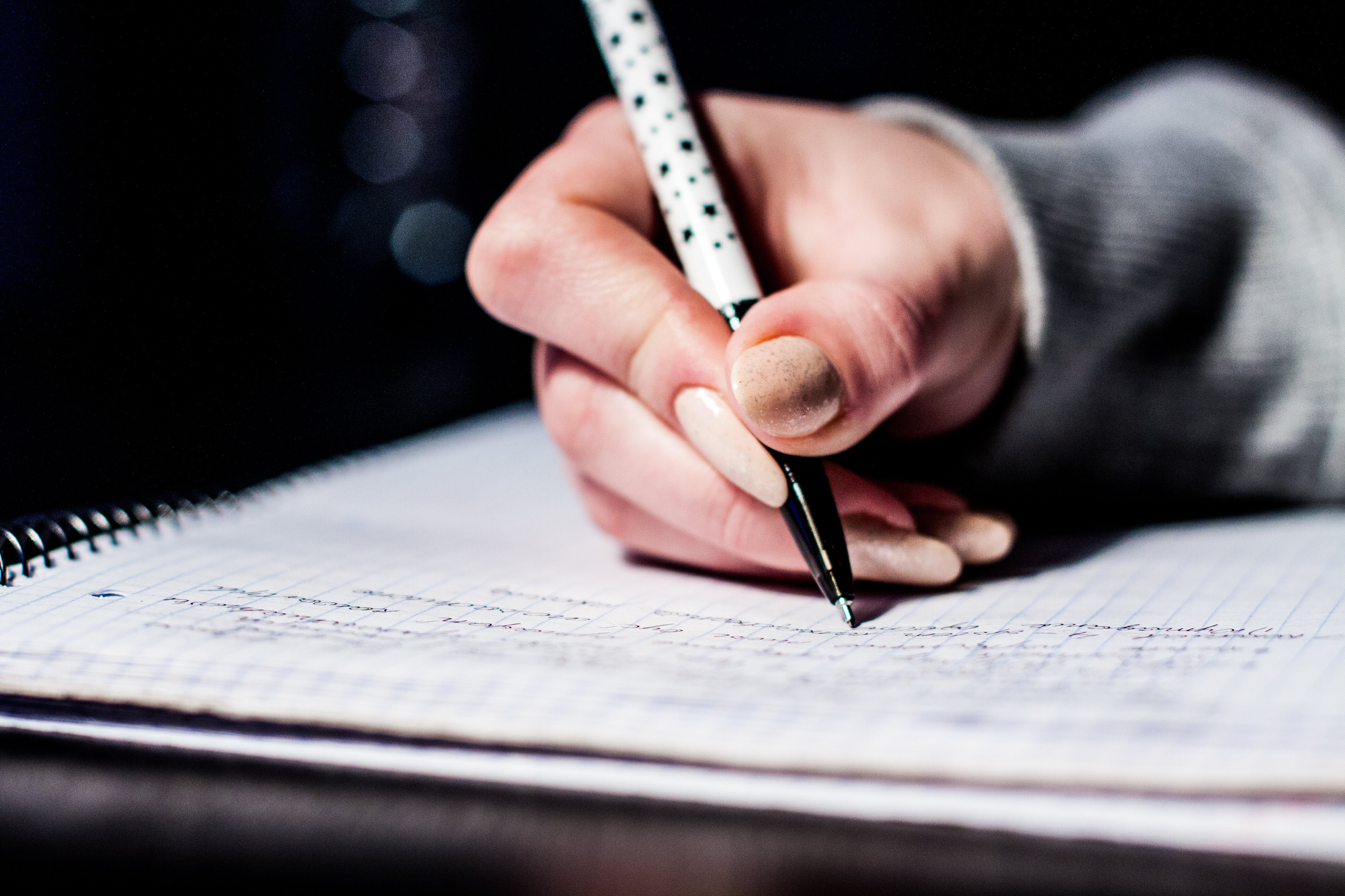 Person writing notes with a pen, representing campaign preparation