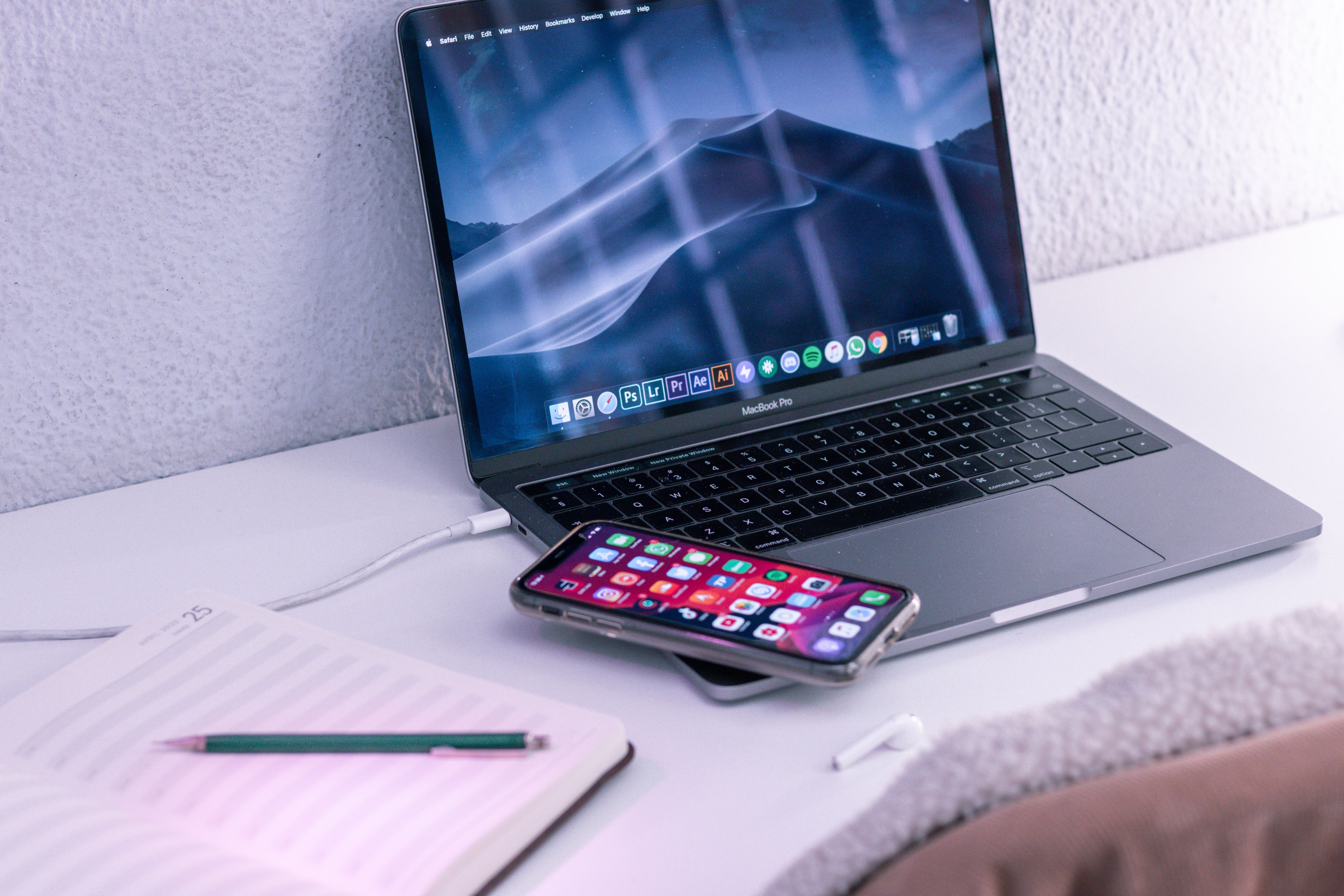 Modern workspace desk setup with a laptop, smartphone, and notepad prepared for online productivity.