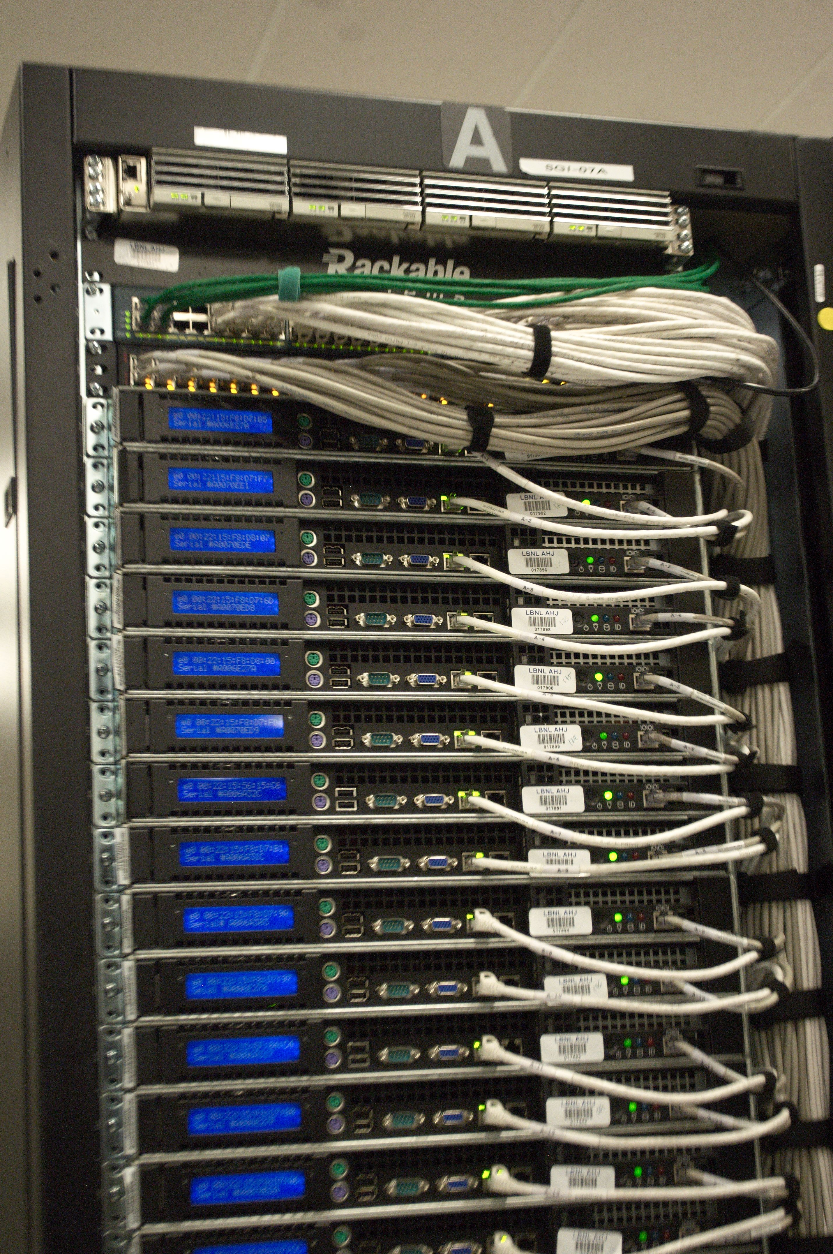 Photograph of the rear of a server rack with dense network cabling in a real data center