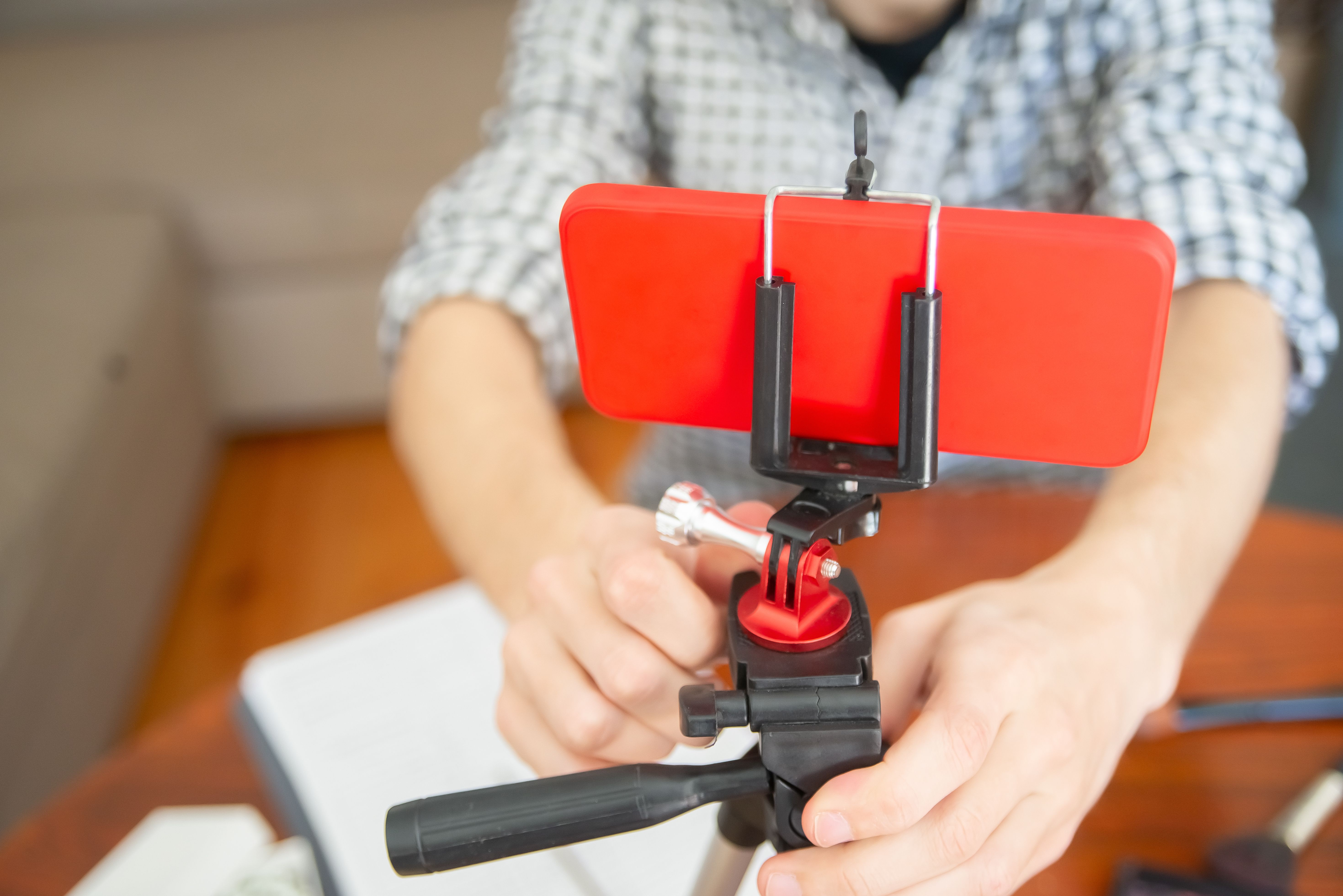 Foto ilustrasi seseorang memasang ponsel di tripod kecil untuk merekam video.