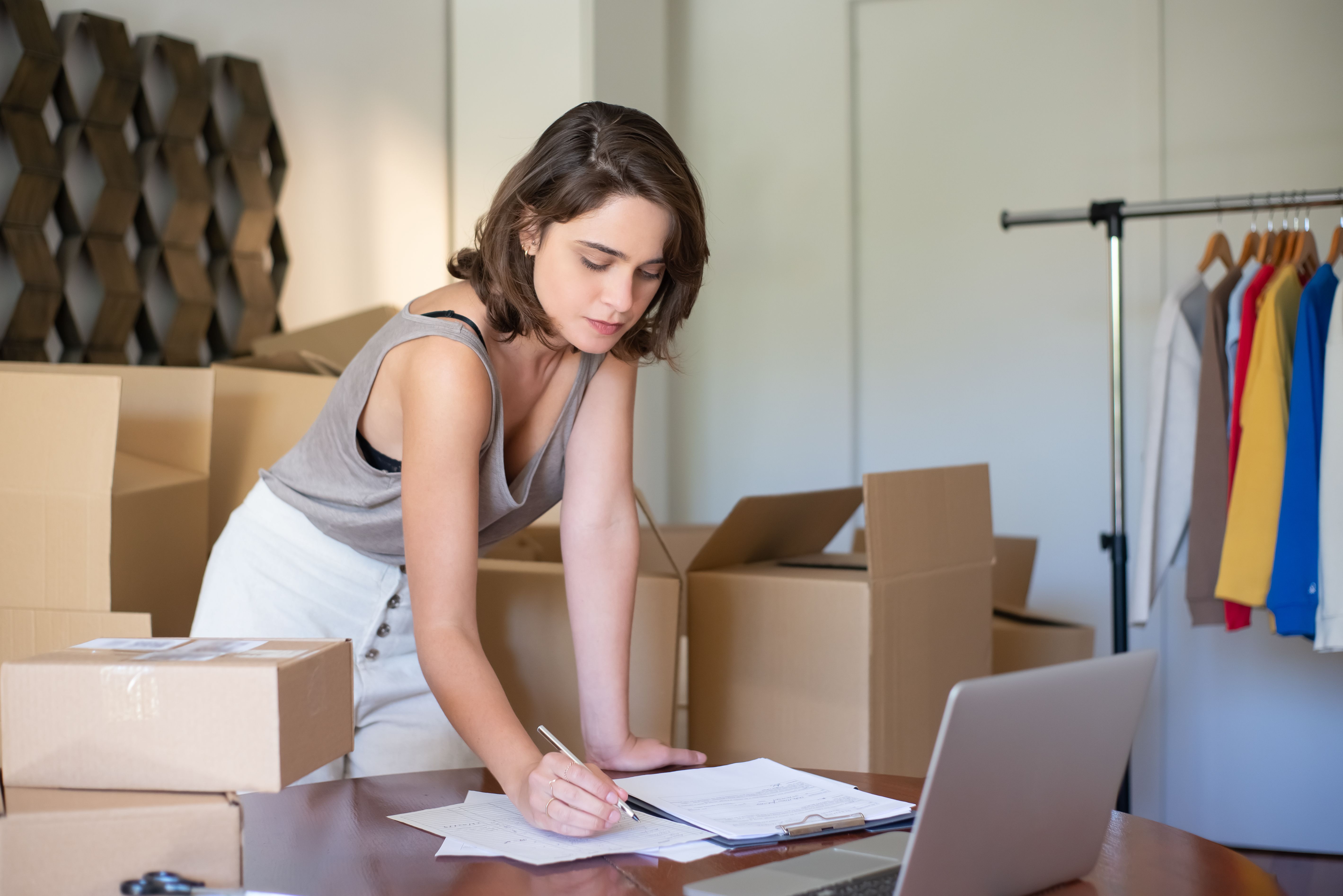 Illustrative stock photo of a person handling packages, paperwork and retail stock.