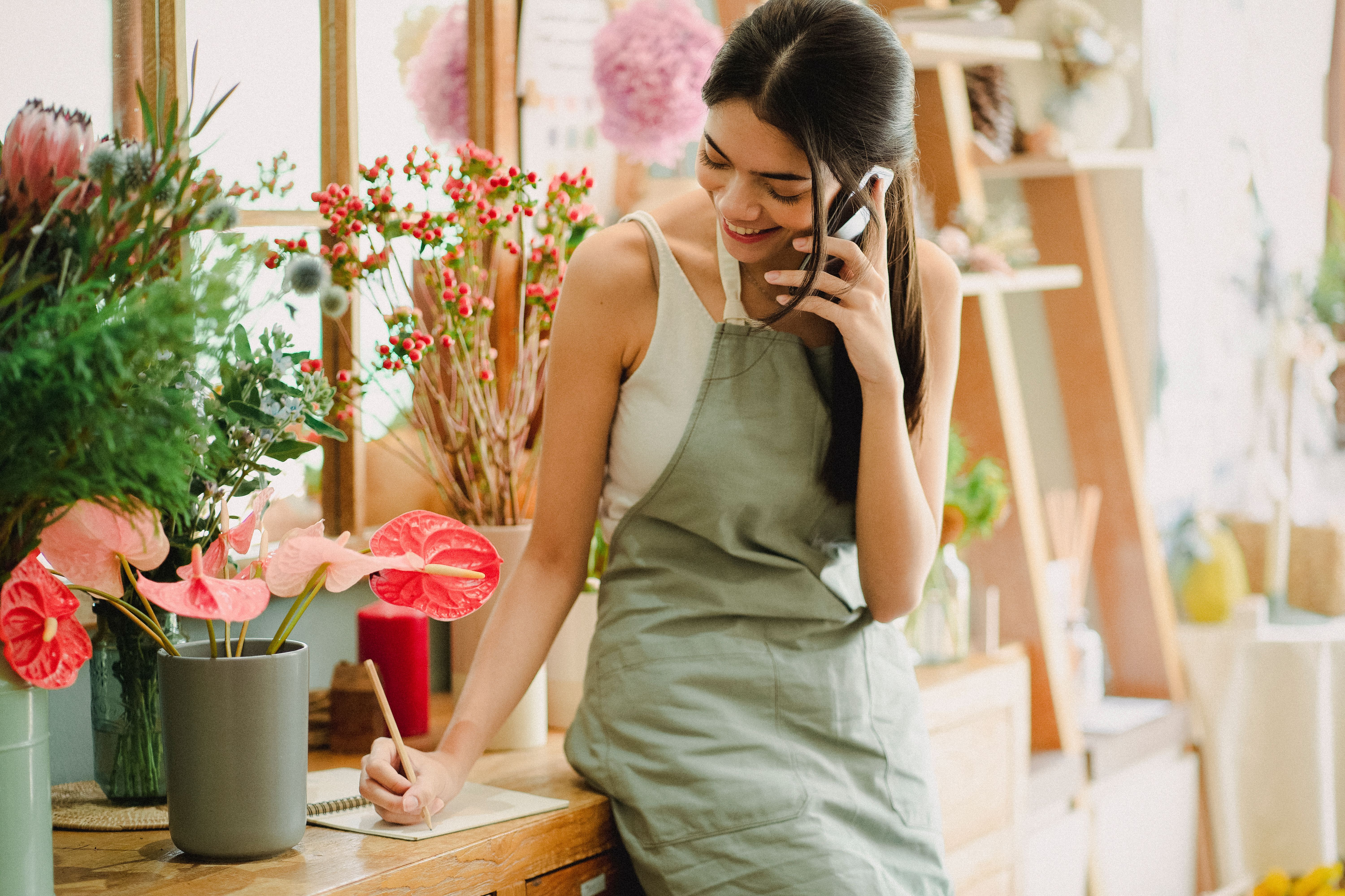 Illustration photo of a small business owner talking on the phone while working in her shop