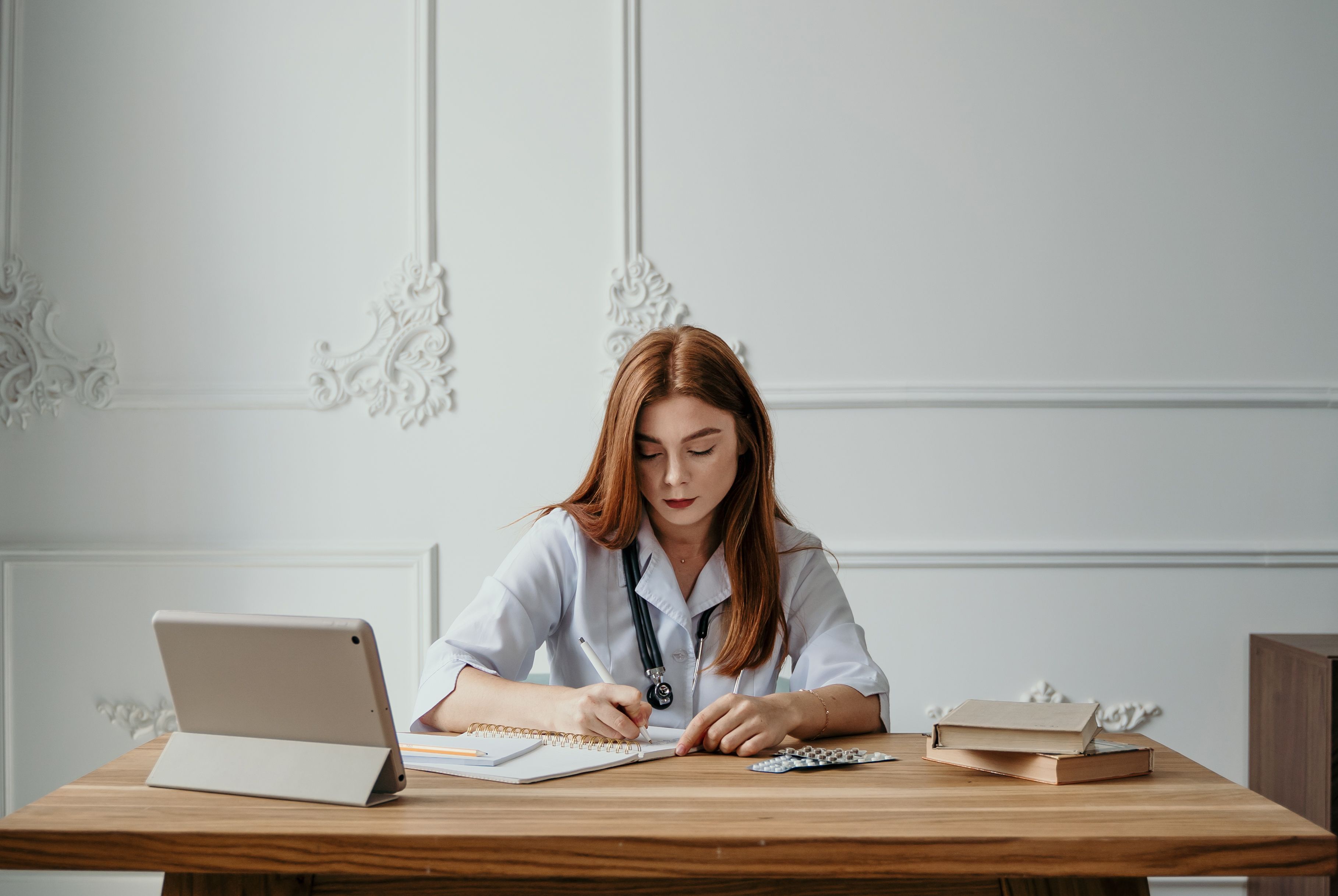 Stock photo of a professional writing notes at a desk.
