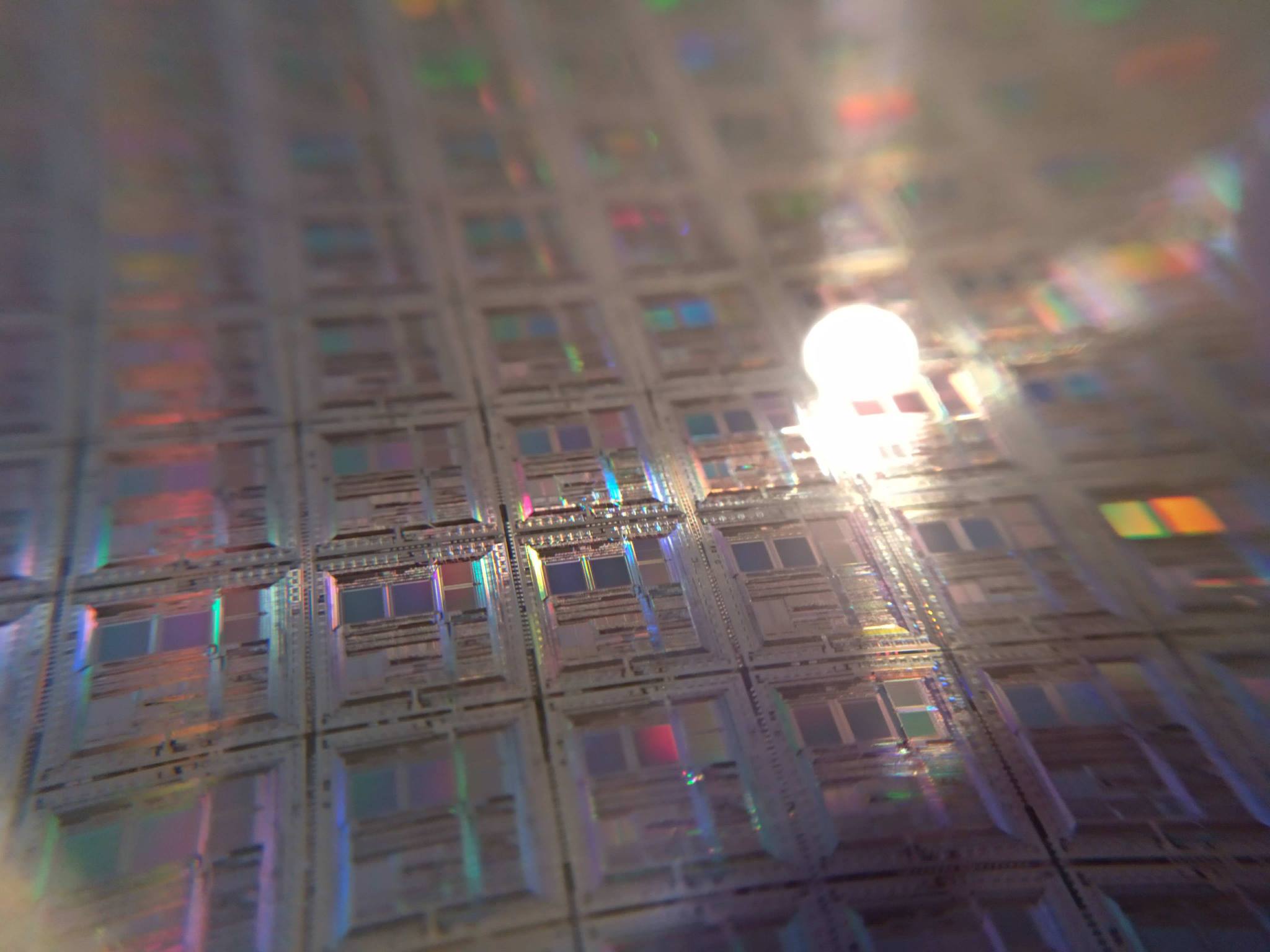 Close-up photograph of microelectronics patterns engraved on a silicon monocrystal wafer used in semiconductor manufacturing.
