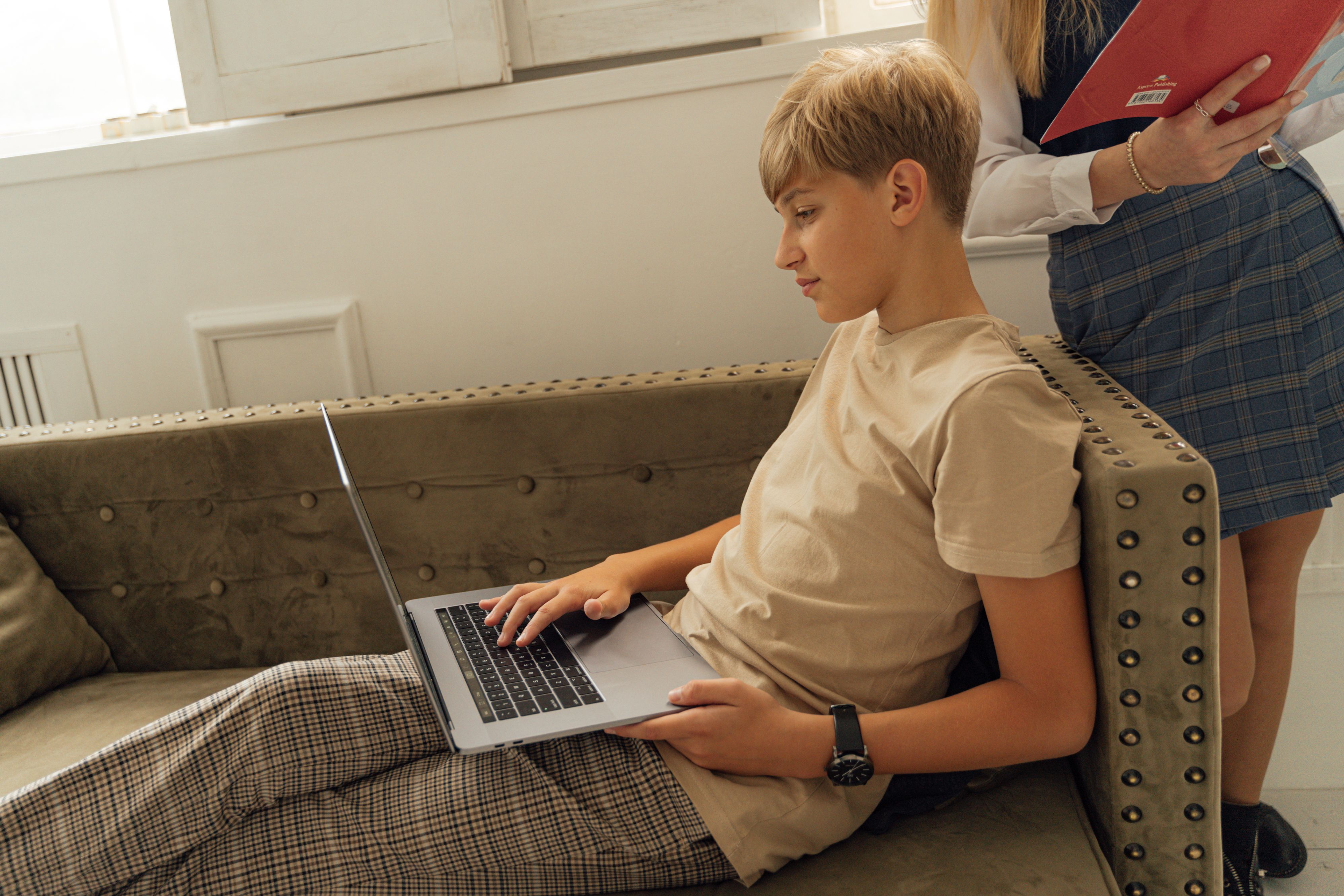 A teenager using a laptop at home.