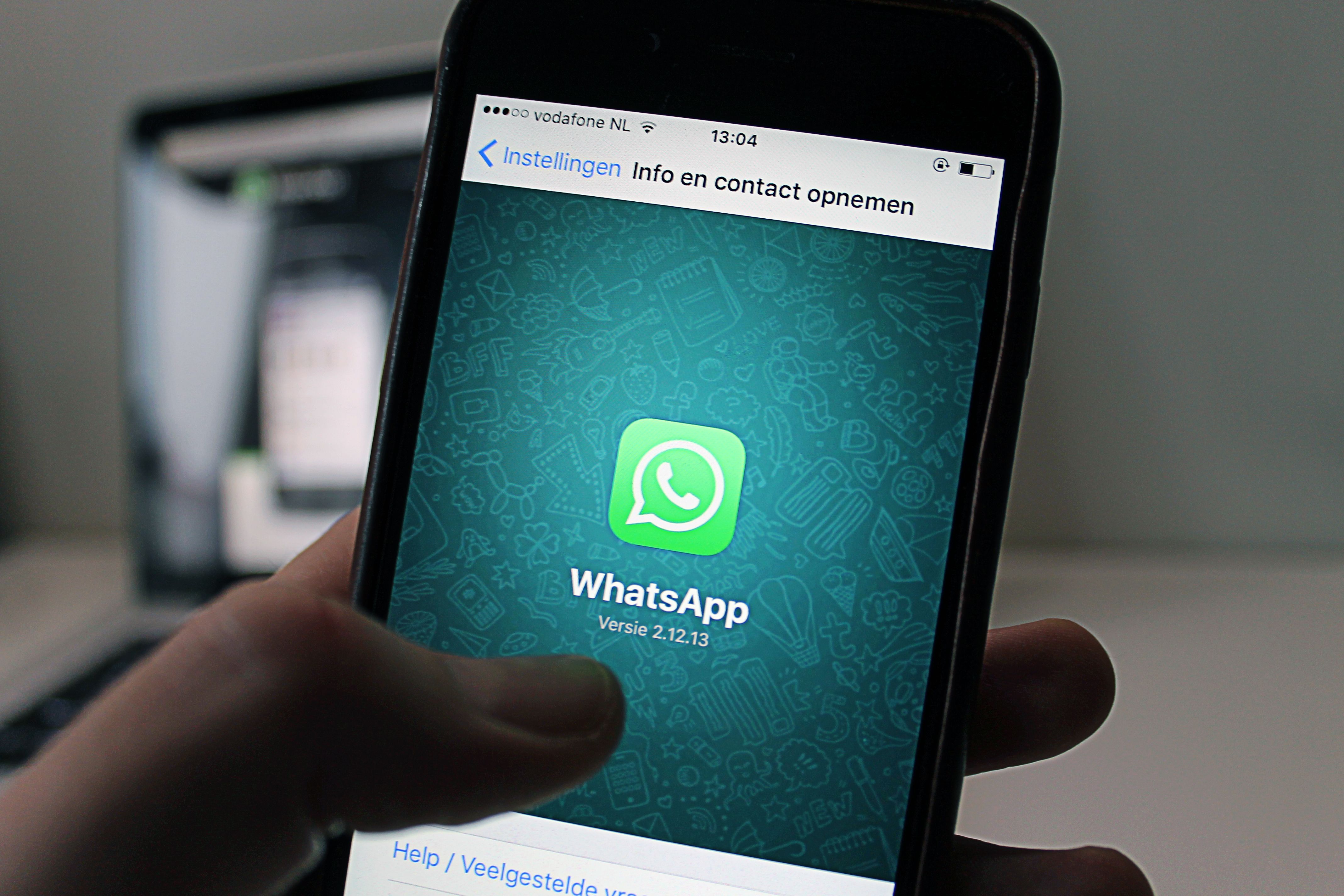 Hand holding phone showing WhatsApp app - illustration